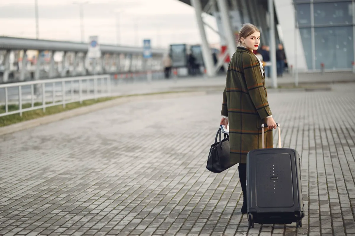 Zakenreis regelen: professional met koffer bij de luchthaven